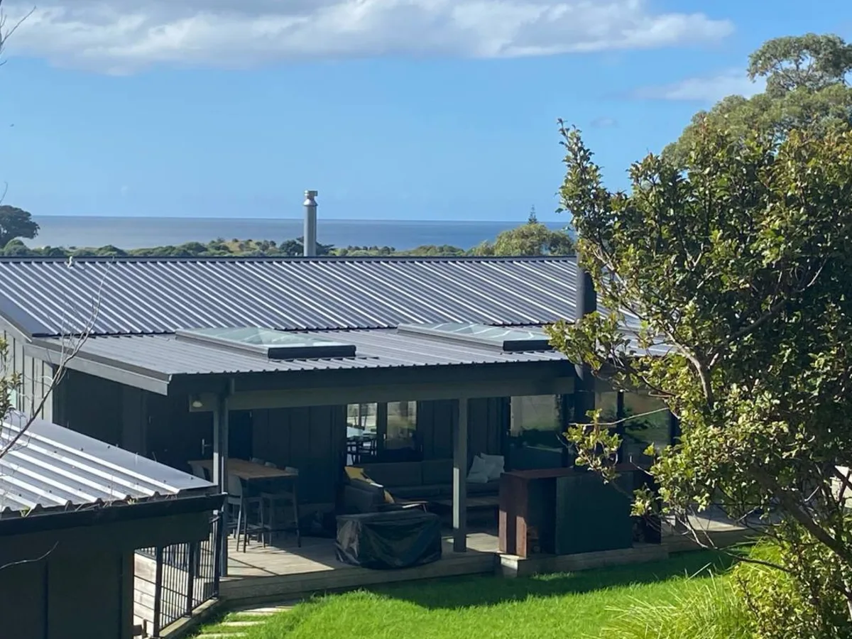 Pītokuku House with lawn and ocean views at Medlands Beach, Great Barrier Island