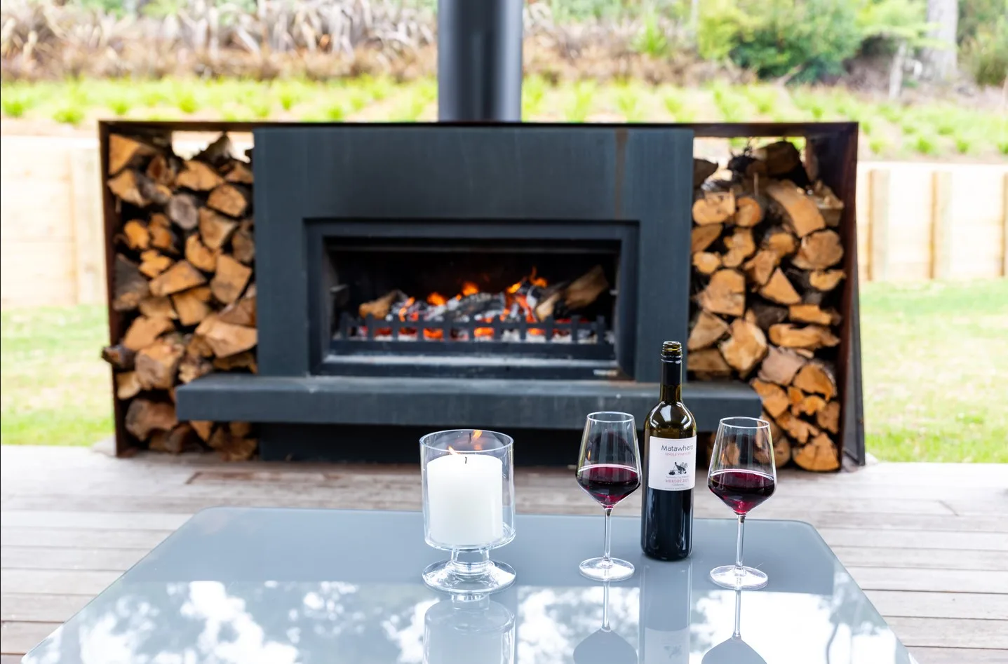 Fire burning on the front deck at Pītokuku House, 175° East, Great Barrier Island in winter