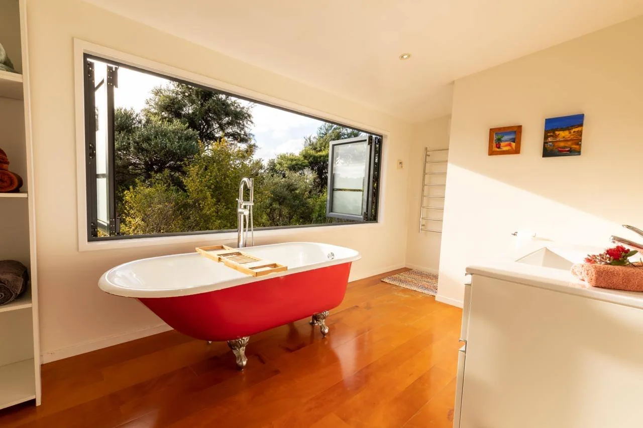 Red clawfoot bath in the Tree House bathroom, Great Barrier Island